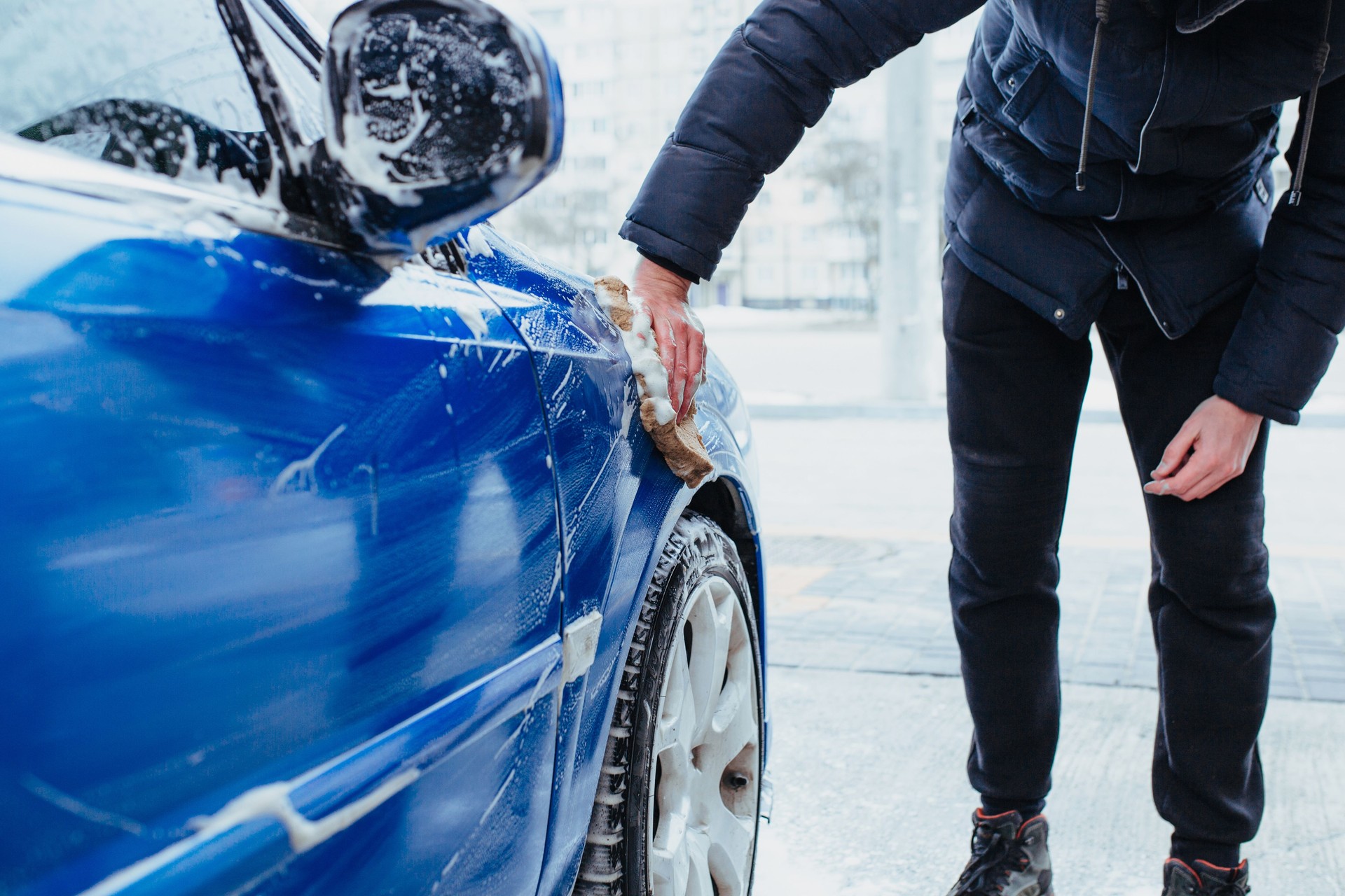 a man washes the car with a washcloth. self-service car wash